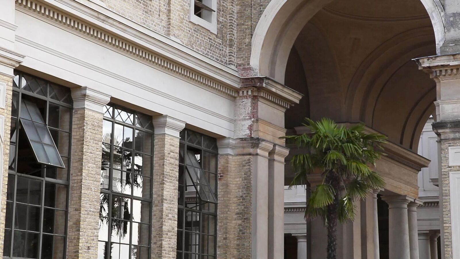 Hausfasssade, heller Backstein, Fenster mit Spiegelung, Palme, Süden, Sonne, Palme in Spiegelung, Rundbogen, Säule